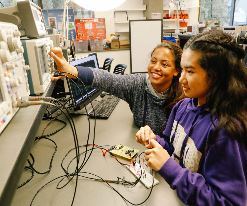 Two students using science equipment at UW